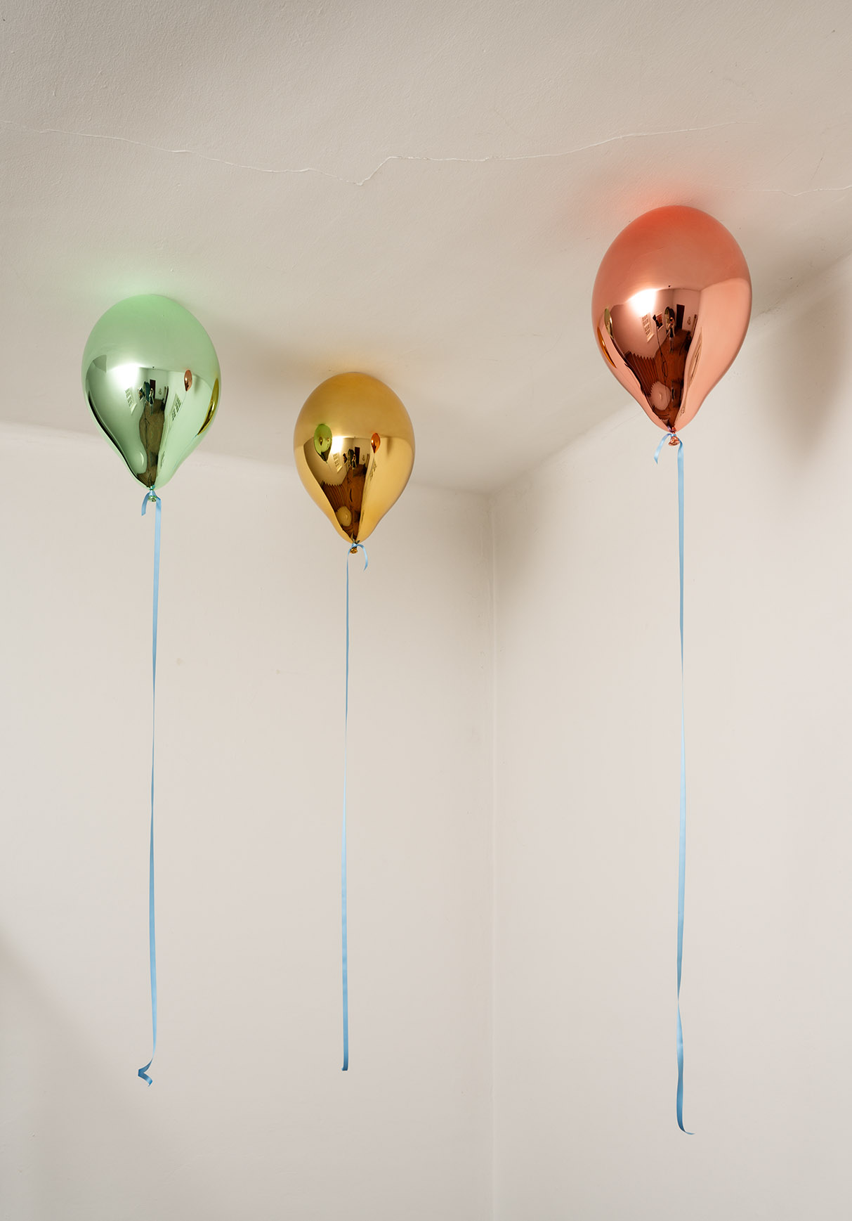 drie gekleurde balonnen hangen aan het plafond